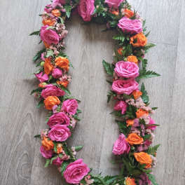 Floral wreath of pink and orange roses on a wood floor