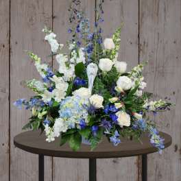 Blue and white floral arrangement in a vase on a table
