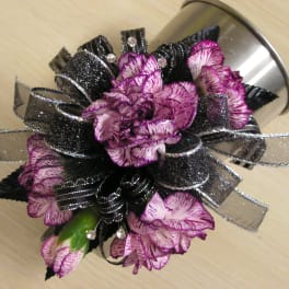 Purple carnations with black ribbon in a silver container