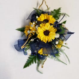 Yellow daisy corsage with navy ribbon and gold accents