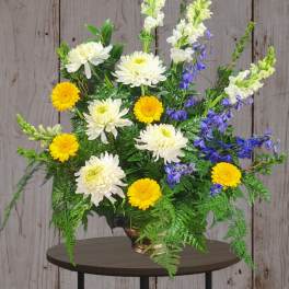 Mixed bouquet with white and yellow flowers in a bronze vase