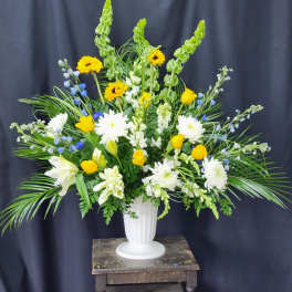 Large white vase arrangement with yellow and white flowers