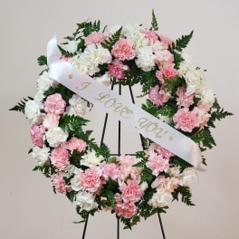 Pink and white carnation wreath with a ribbon reading "I love you"