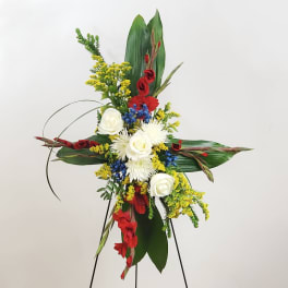 Tall floral standing spray with red, white, yellow, and blue flowers