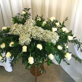 Large white floral spray with roses and baby's breath in a vase