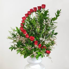 Tall arrangement of red roses in a white vase