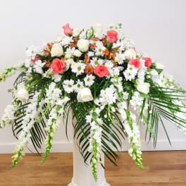 Large floral arrangement of pink and white roses with cascading white blooms