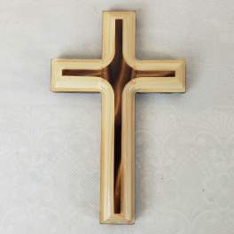 Wooden cross on a light fabric background