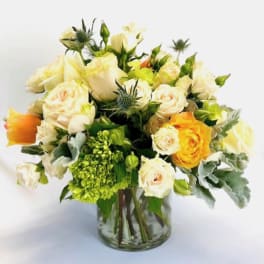 Bouquet of cream and yellow roses in a clear glass vase