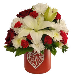 Red and white flower arrangement in a red heart-decorated box