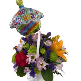 Birthday flower basket with a balloon and mixed blooms in a white basket