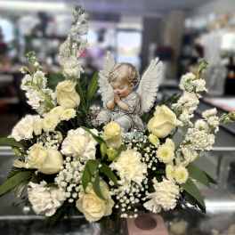 White floral arrangement with an angel figurine centerpiece