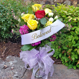 Bouquet of yellow and red roses with pink flowers and a lavender ribbon