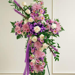 Standing floral spray with pink and white flowers and a purple ribbon