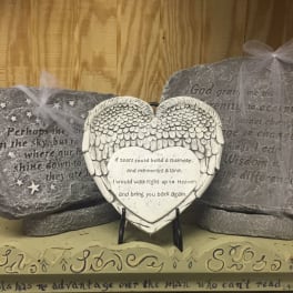 Heart-shaped memorial plaque with angel wings on a stand
