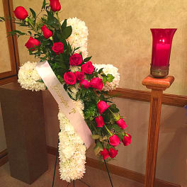Standing floral spray with red roses and white chrysanthemums on an easel