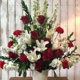 Red roses and white lilies arranged in a white vase