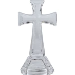 Clear glass cross-shaped decorative object on a white background