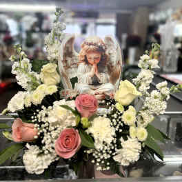 Pink and cream roses with white flowers around an angel card