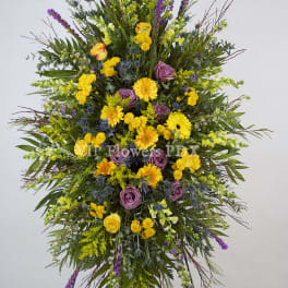 Large standing spray of yellow, purple, and green flowers on an easel