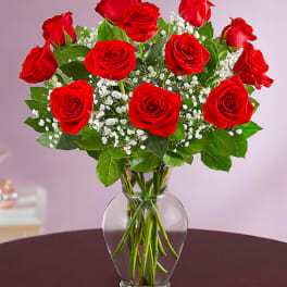 Red roses in a clear glass vase with baby's breath