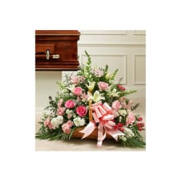 Pink and white floral casket spray with a ribbon bow