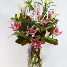 Pink lilies arranged in a clear glass vase