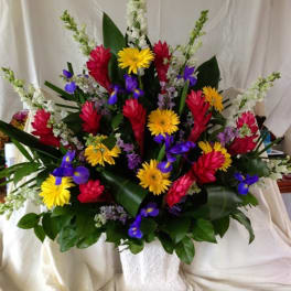 Colorful tropical flower arrangement in a white basket