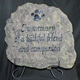 Memorial stone with a paw print and engraved tribute text