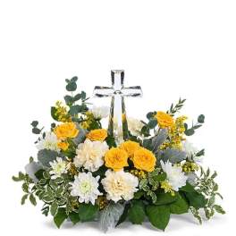 Yellow and white floral arrangement with a clear glass cross centerpiece