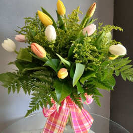 Mixed tulip bouquet in a glass vase with a pink plaid ribbon