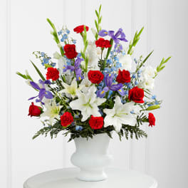 Mixed bouquet of red, white, and purple flowers in a white vase