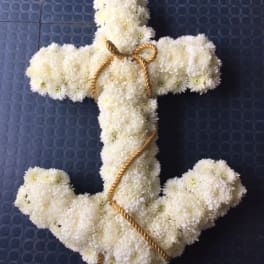 White chrysanthemum cross with gold rope trim on a dark blue background