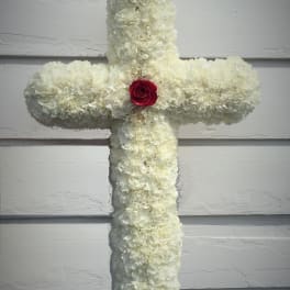 White floral cross with a red rose at the center