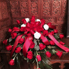 Red roses and white carnations arranged with red ribbons