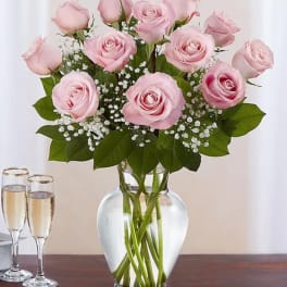 Pink roses arranged in a clear glass vase with baby's breath