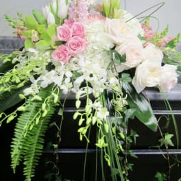 Large floral arrangement with pink and white blooms and cascading greenery
