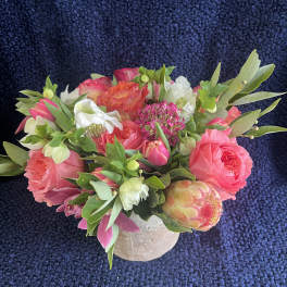 Pink and white mixed bouquet in a small beige vase