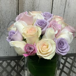 Pastel roses arranged in a clear square vase