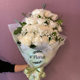 Bouquet of white roses with baby's breath wrapped in pale paper