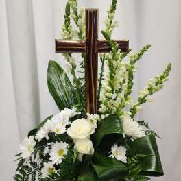 White floral arrangement with a wooden cross centerpiece