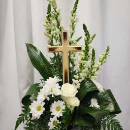 White floral arrangement with a wooden cross and daisies