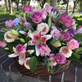Basket of pink roses and lilies with white daisies