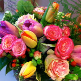 Bouquet of pink and yellow tulips with pink roses in a vase
