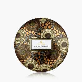 Round floral-patterned candle tin labeled Baltic Amber