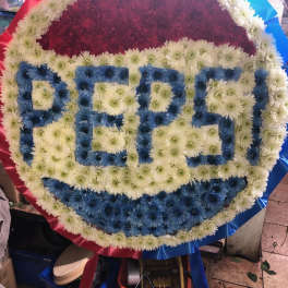 Large floral wreath with the word PEPSI in blue and white flowers