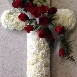 Cross-shaped floral arrangement with red roses and white blooms