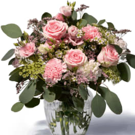Pink roses and carnations in a clear glass vase