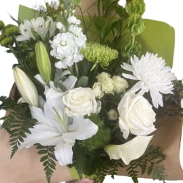 White bouquet with lilies, roses, and chrysanthemums wrapped in brown paper