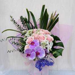 Bouquet of pink roses and purple orchids with white filler flowers